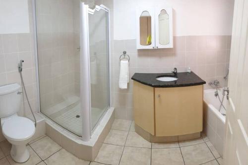 KingsboroughにあるLa Mer Stunning Beachfront Apartmentのシャワー、トイレ、洗面台を備えたバスルーム