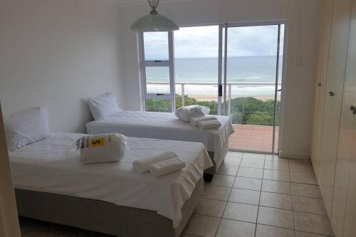 KingsboroughにあるLa Mer Stunning Beachfront Apartmentの海の見える部屋にベッドが2つあります