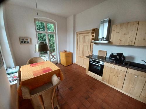 a kitchen with a table and a kitchen with a stove at FeWo "Falter" im Kunstgut Krahne in Krahne