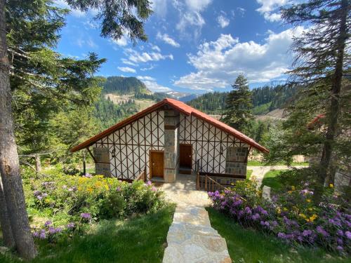 a small cabin in a garden with flowers at Foleya Mountain Resort Hotel & Villas in Trabzon