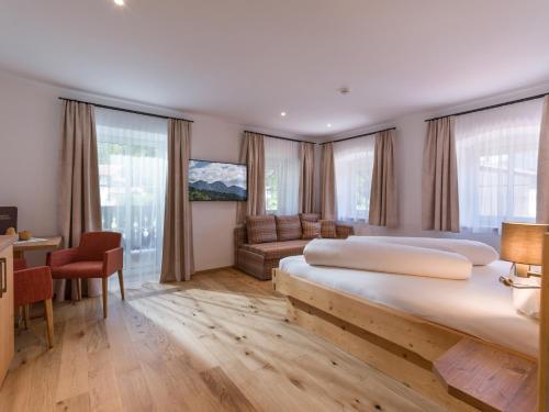 a hotel room with two beds and a couch at Postgasthof Fischerwirt in Walchsee