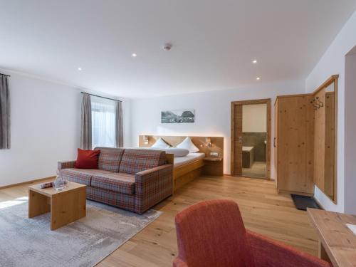 a living room with a couch and a bed at Postgasthof Fischerwirt in Walchsee