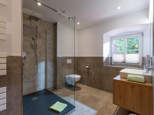 een badkamer met een douche, een toilet en een wastafel bij Postgasthof Fischerwirt in Walchsee