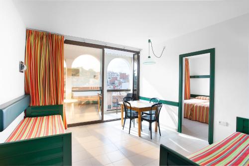 a room with a table and a bed and a window at Apartaments Rosanna in Lloret de Mar