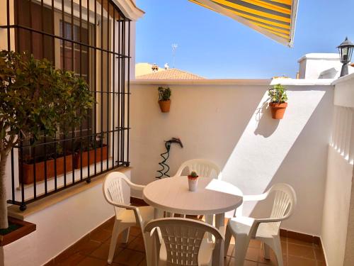 a patio with a table and chairs on a balcony at Mar Azul in Chiclana de la Frontera