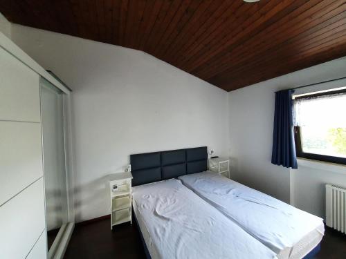ein Schlafzimmer mit einem großen Bett und einem Fenster in der Unterkunft Ferienhaus Stausee Eifel in Biersdorf
