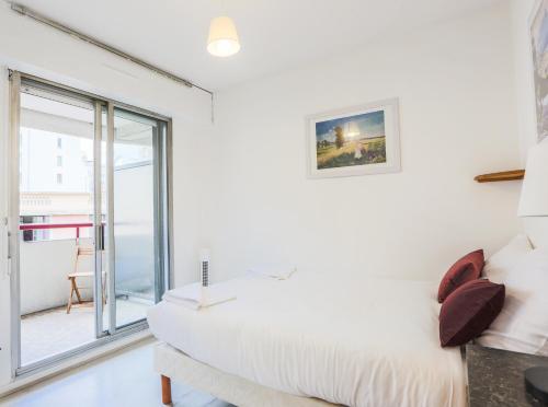 a white bedroom with a bed and a window at "CHAMPÊTRE" Confort in Clermont-Ferrand
