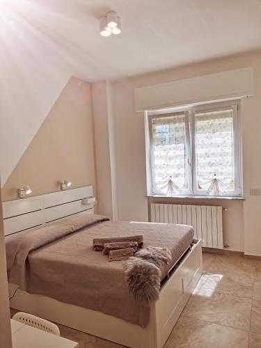 ein Schlafzimmer mit einem großen Bett und zwei Fenstern in der Unterkunft "Nonna Maria" in Venegono Superiore
