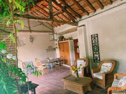 a patio with a table and chairs in a room at Casa Jardín El Arco in Coca