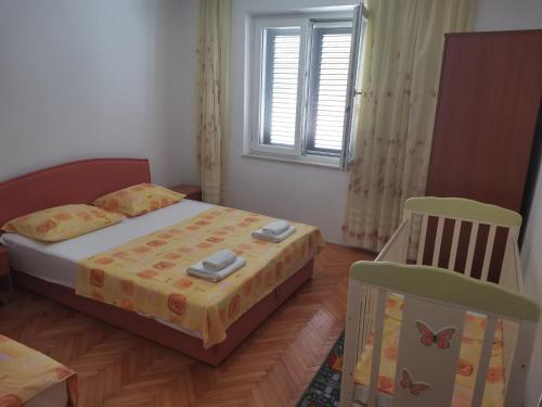 a bedroom with a bed and a chair and a window at Apartman Niko Promajna in Promajna
