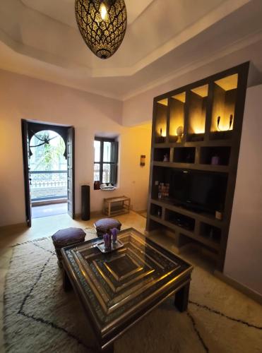 a living room with a coffee table and a tv at Dar Andamaure in Marrakech