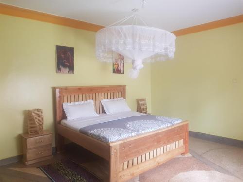 1 dormitorio con cama y lámpara de araña en House 1759, near River Nile en Jinja