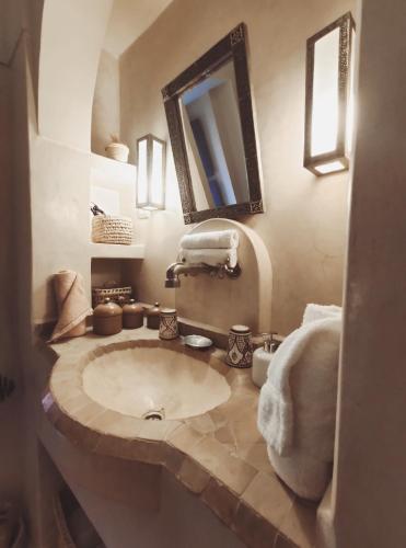 a bathroom with a sink and a mirror at Dar Andamaure in Marrakech