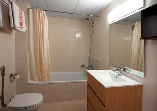 a bathroom with a sink and a tub and a toilet at Apartaments Rosanna in Lloret de Mar