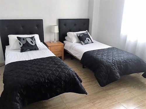 ハベアにあるLuxury apartment near Arenal beach Javea Sleeps 6 Fully equipped Full AirConのベッドルーム1室(ベッド2台、ナイトスタンド付)