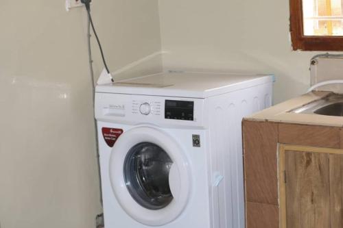 a washing machine in a kitchen next to a sink at House 1759, near River Nile in Jinja