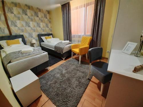 een hotelkamer met 2 bedden en een bureau bij Apartman Lara in Foča