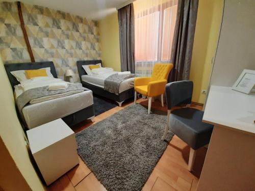 a room with two beds and a table and chairs at Apartman Lara in Foča