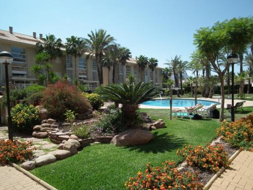 ハベアにあるLuxury apartment near Arenal beach Javea Sleeps 6 Fully equipped Full AirConのヤシの木が植わるリゾートヤード