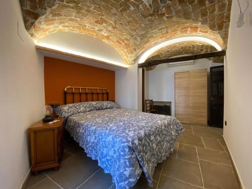 een slaapkamer met een bed en een stenen plafond bij La Casa de Abajo in Puerto de Santa Cruz