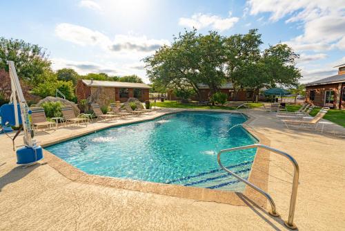 a large swimming pool with chairs and a house at Sun Outdoors Lake Travis in Hudson Bend