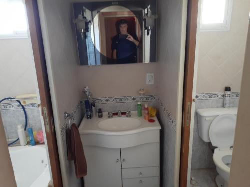 a person taking a picture of a bathroom with a sink at Lugar Maravilloso in Sierra de la Ventana