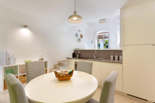 a kitchen and dining room with a white table and chairs at "Le Casette di Ninetta" - Casa Casmene in Donnalucata
