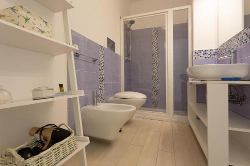 a bathroom with a white toilet and a sink at "Le Casette di Ninetta" - Casa Casmene in Donnalucata