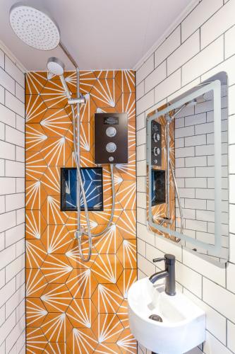 a bathroom with a sink and a mosaic wall at Brighton Laines Apartments - Central Laines Location in Brighton & Hove