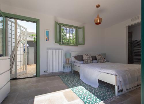 een slaapkamer met een bed en een glazen schuifdeur bij Casa Amahoro in Ostuni