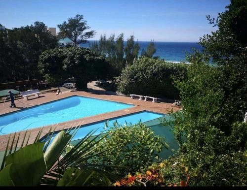 a swimming pool with the ocean in the background at 705 Umdloti Resort in Umdloti