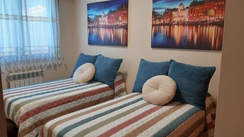 two beds sitting next to each other in a room at Apartamento in Ferrol