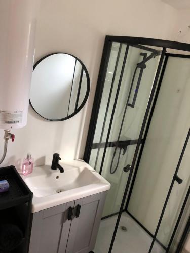 a bathroom with a sink and a shower with a mirror at Skrundas namiņš in Skrunda