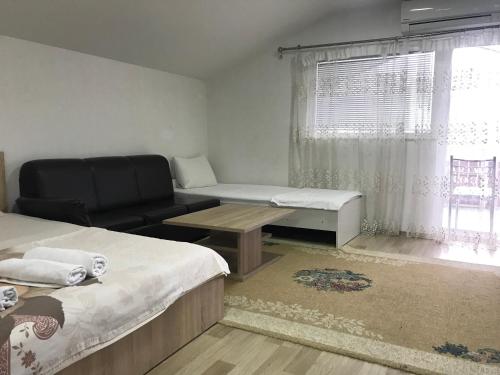a room with two beds and a couch and a window at Venecia Plaza Struga in Struga