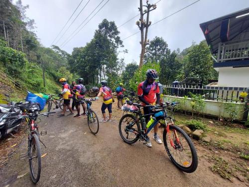 a group of people riding bikes on a dirt road at Eden Homestay Idukki in Idukki