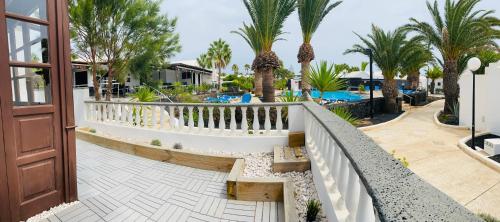 - un balcon avec des palmiers et une piscine dans l'établissement LC Bastian Marina Bungalow, à Costa Teguise