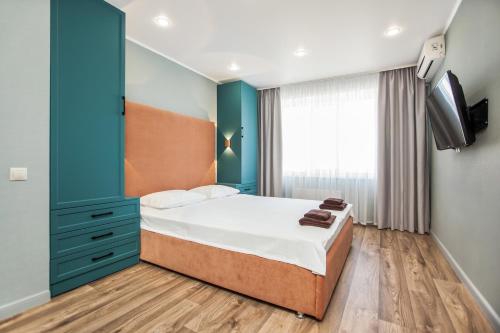 a bedroom with a bed and a flat screen tv at KvartHaus na 70 let Oktyabrya in Tolyatti