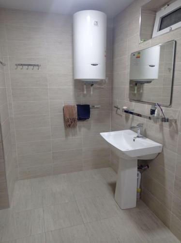 a white bathroom with a sink and a mirror at Comfortable Home Stay in Termiz