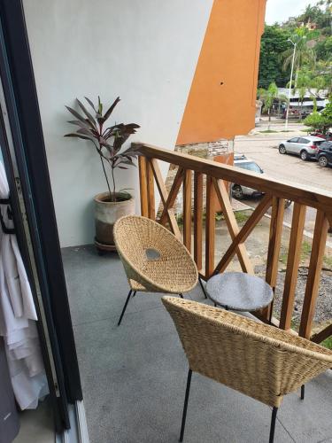 a balcony with two chairs and a table and a plant at Ximena Hotel Boutique in Sayulita