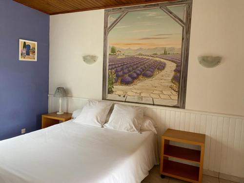 een slaapkamer met een wit bed en een schilderij aan de muur bij Hôtel Restaurant Le Relais de l'Estuaire in Étauliers