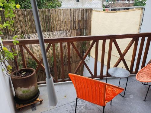 a balcony with a baseball bat and chairs and a fence at Ximena Hotel Boutique in Sayulita