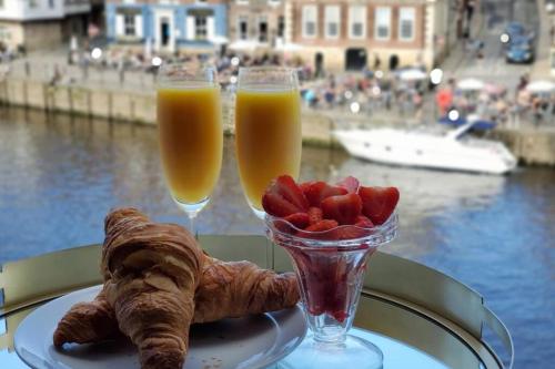 two glasses of orange juice and pastries on a table at The Riverside at Woodsmill Quay with parking in York