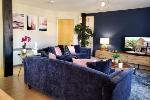 a living room with two blue couches and a table at The Riverside at Woodsmill Quay with parking in York