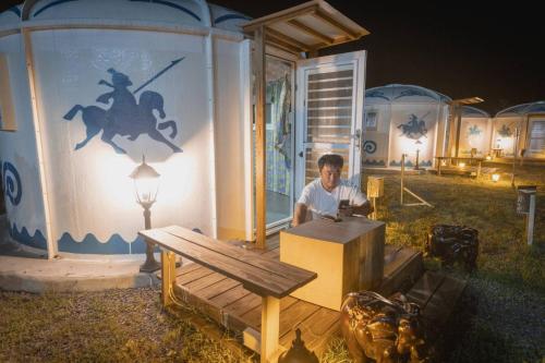 a man sitting at a table in front of a house at 枋山六號 in Fangshan