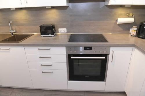 a kitchen with a stove and a sink at Helle, Ruhige, Moderne Wohnung, 5 min zu Fa GROB in Mindelheim