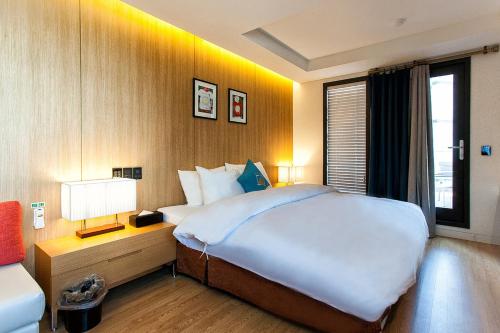 a hotel room with a large bed and a window at Golden Hotel Incheon in Incheon