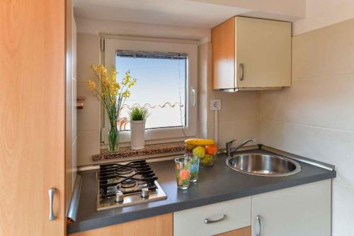 małą kuchnię ze zlewem i oknem w obiekcie Studio in Stara Baska/Insel Krk 34432 w mieście Stara Baška