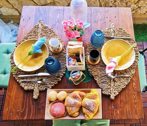 een houten tafel met borden eten en brood bij Favola Exclusive b&b in Pescara