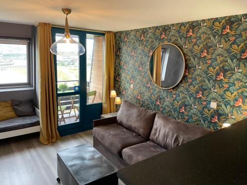 - un salon avec un canapé et un miroir dans l'établissement Deauville marina - Escapade vue mer, à Deauville