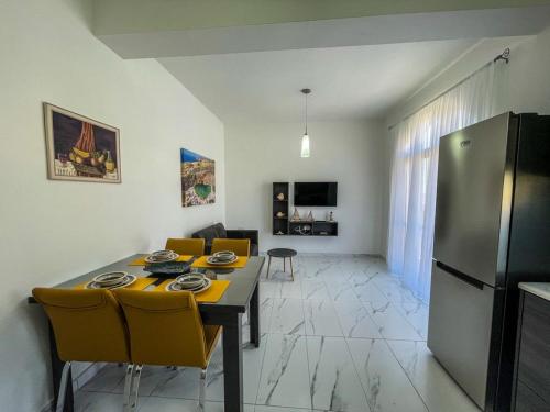 una cucina e una sala da pranzo con tavolo e frigorifero di Sun Sea Living Gozo a Xlendi